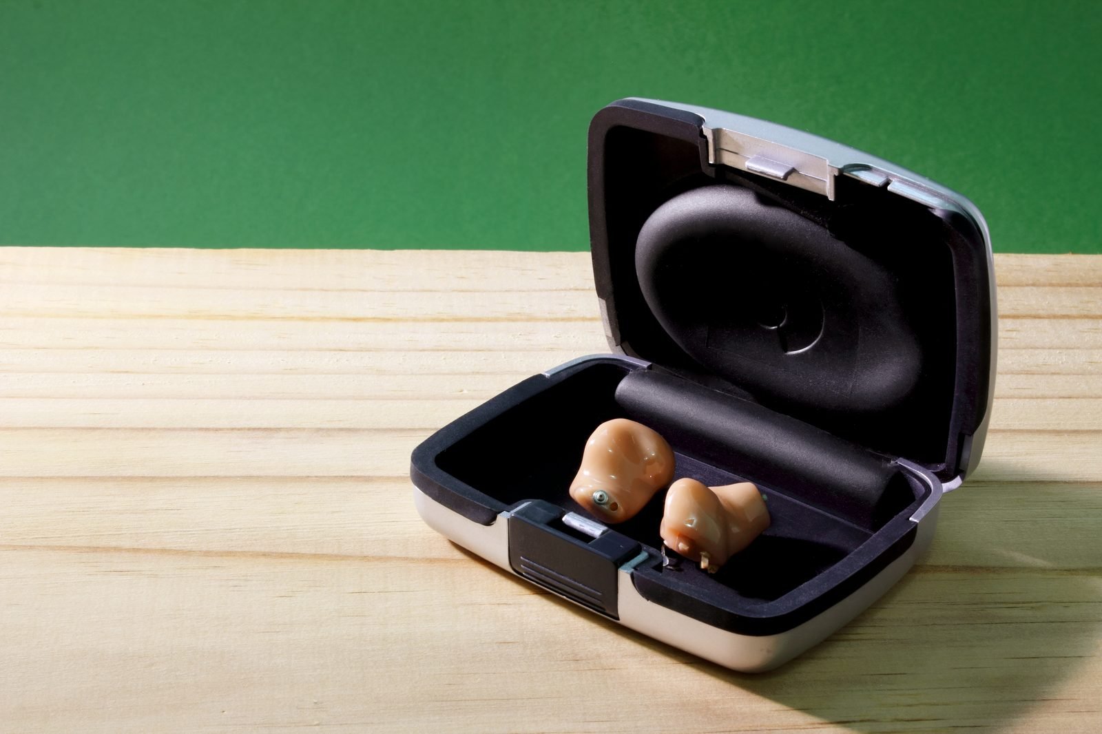 A pair of hearing aids in their charging case