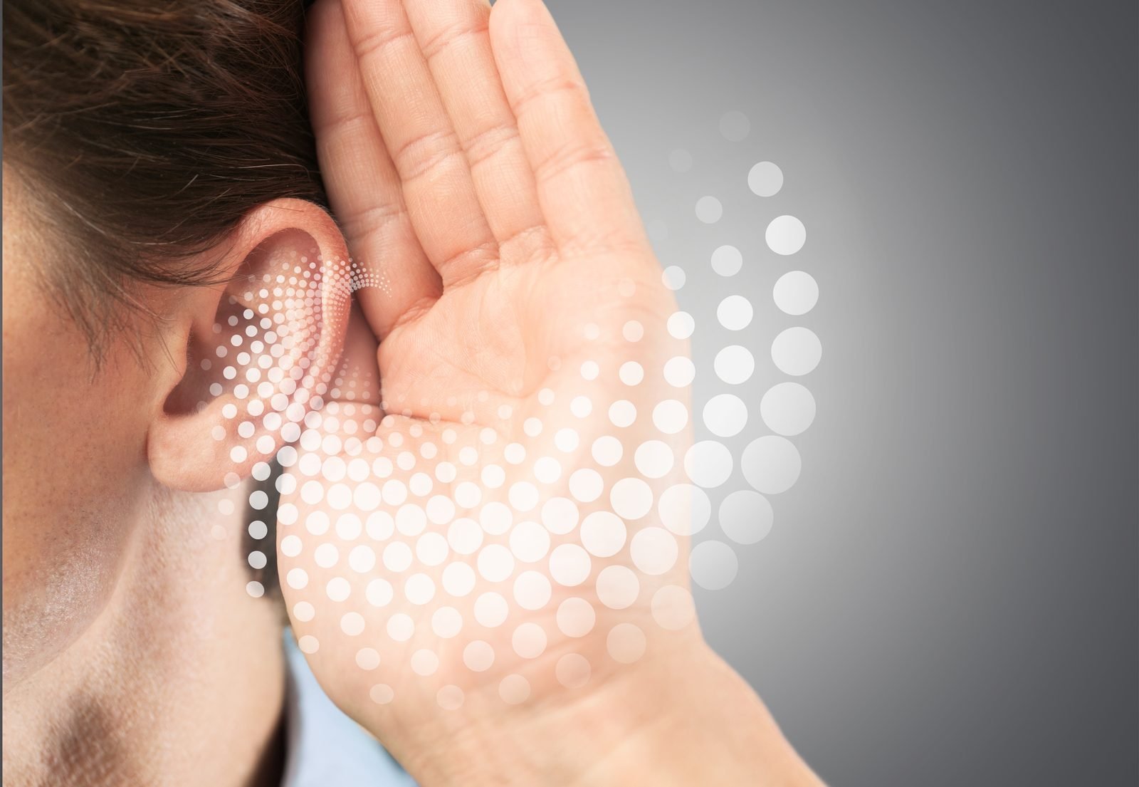A hand cupped to an ear, listening closely