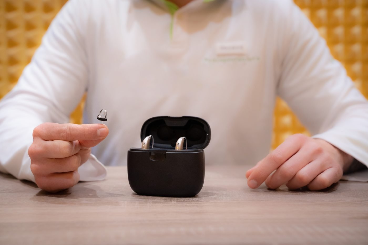 A pair of hearing aids resting in their charging case